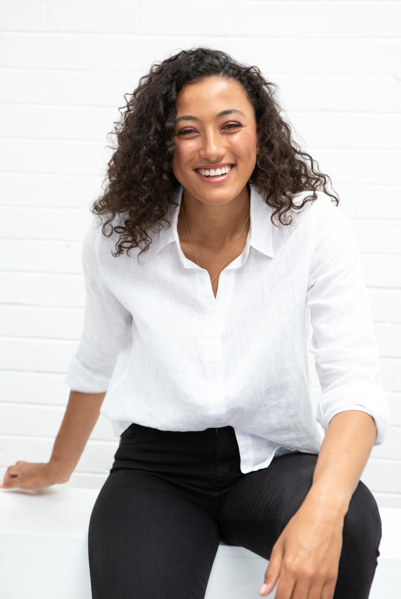 A model wearing a white linen shirt and black pants