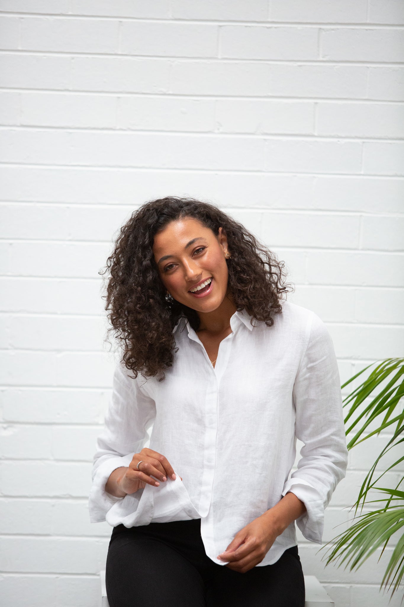 A model wearing a white linen shirt and black pants